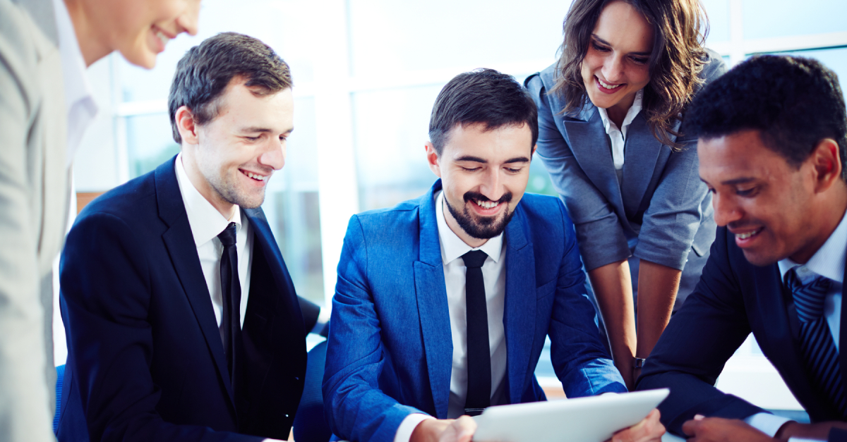 Reasons to Outsource Your Payroll Management System | TopSource Blog Feature Image - Employees working together at desk