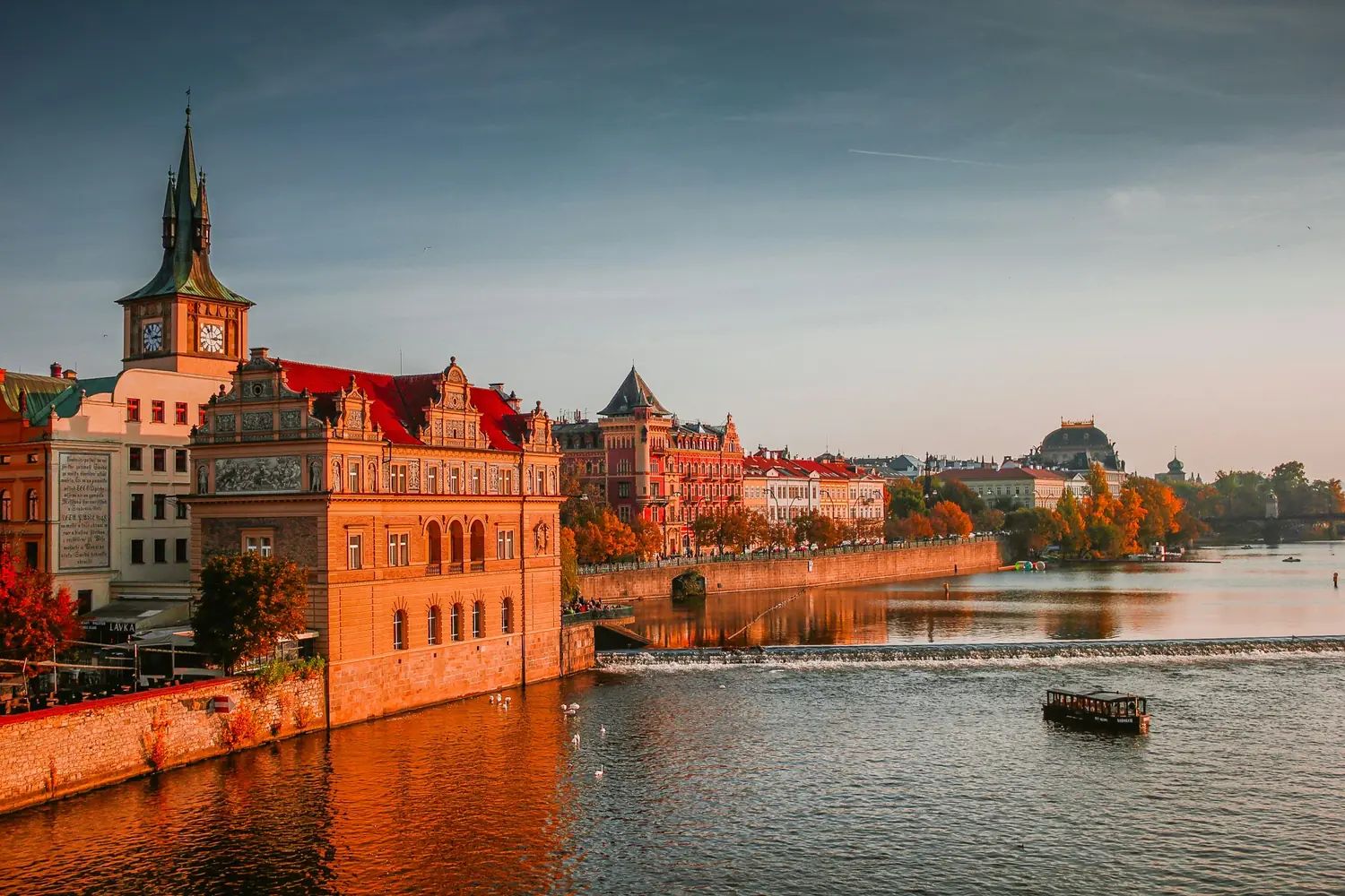 Vltava river and the historic Prague waterfront glowing at sunset, Czech Republic