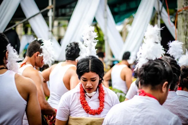 Fijians in traditional dress with feather headpieces and salusalu garlands at a ceremony, Fiji
