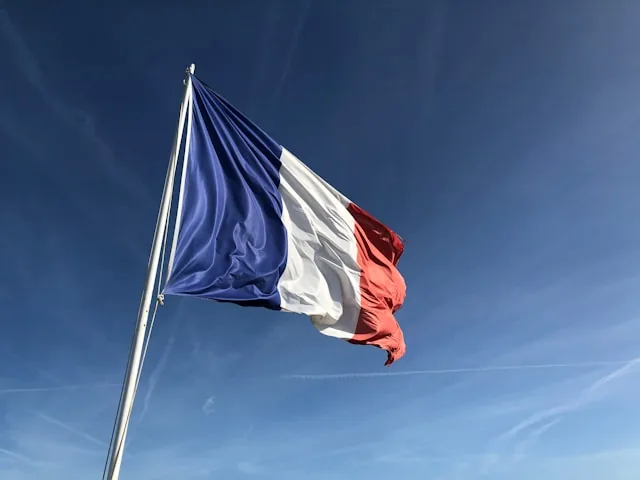The French tricolour flying against a clear blue sky, France