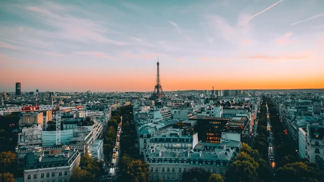 The Paris skyline at sunset seen from the Arc de Triomphe, with the Eiffel Tower and Haussmann rooftops, France
