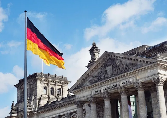 The German flag flying in front of the Reichstag building in Berlin, Germany