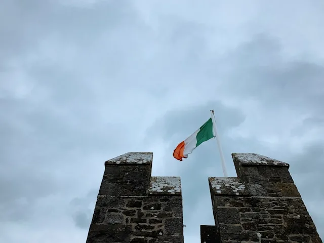 The Irish tricolour flying over castle battlements, Ireland