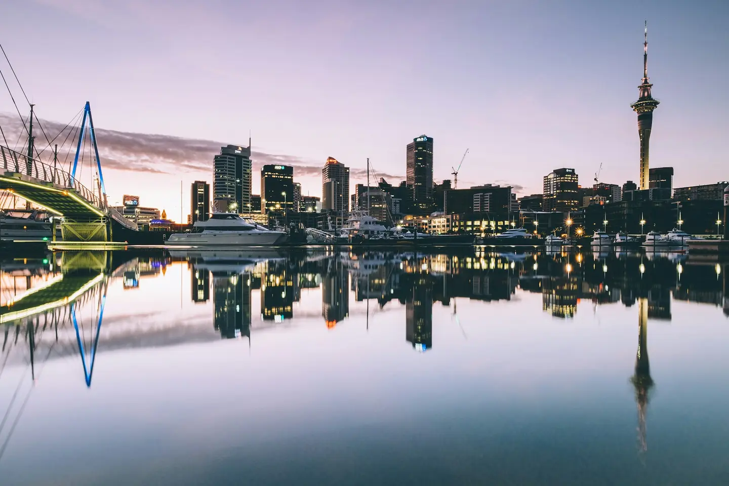 Auckland skyline and Sky Tower at dusk over the Viaduct Harbour, New Zealand