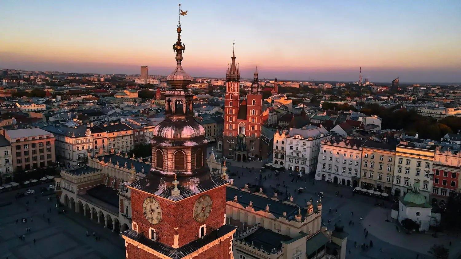 Aerial view of the Main Market Square in Krakow at dusk, with the Town Hall Tower, the Cloth Hall and St Mary's Basilica, Poland