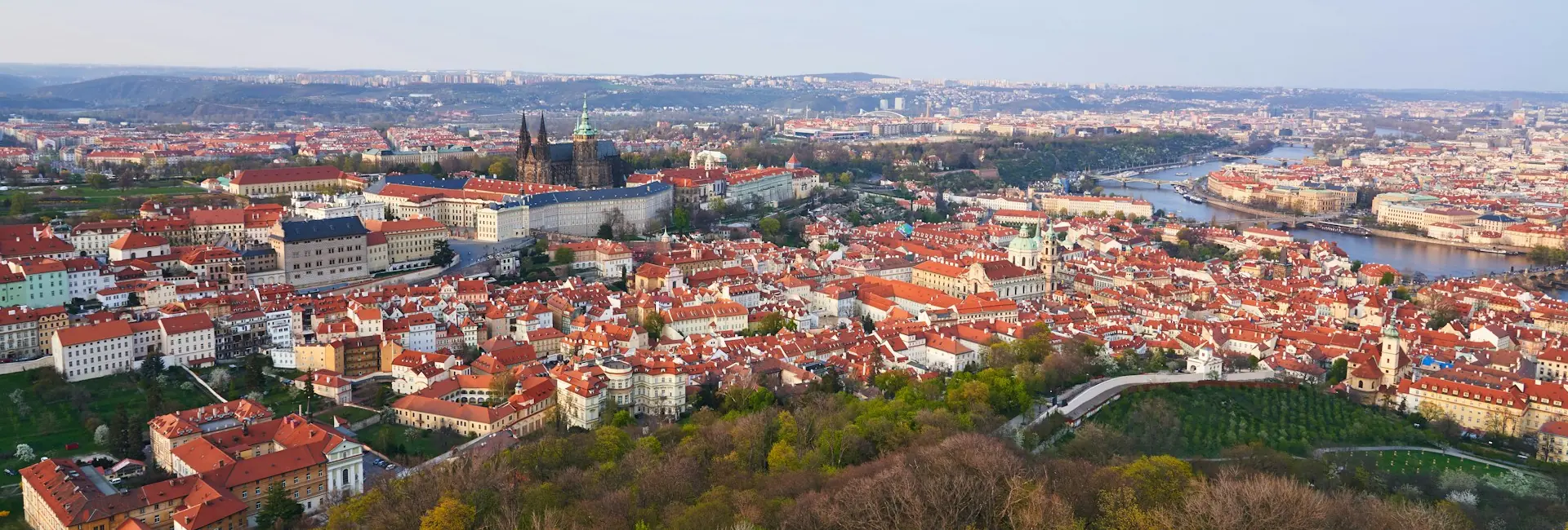 Prague Castle and St. Vitus Cathedral above the red rooftops of the Lesser Town, with the Vltava River and its bridges on the right, Prague, Czech Republic