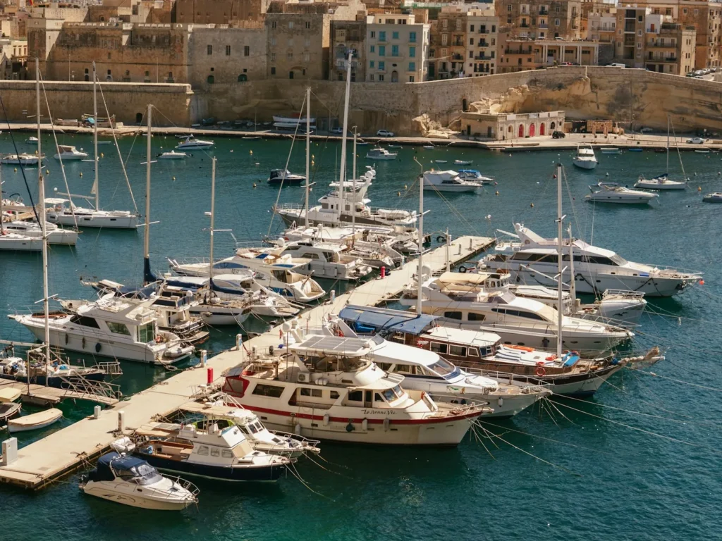 Boats moored along the pontoons of the Dockyard Creek marina below the Birgu fortifications in the Grand Harbour, Malta