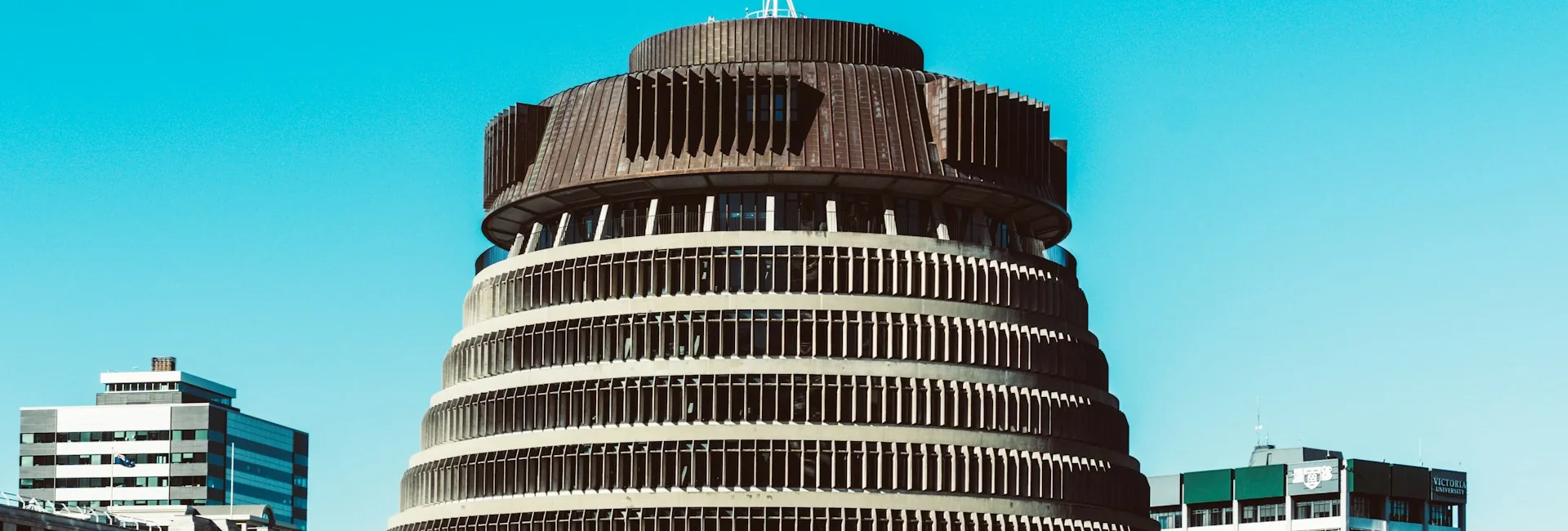 The Beehive, the executive wing of the New Zealand Parliament, between office buildings in central Wellington under a clear sky, Wellington, New Zealand