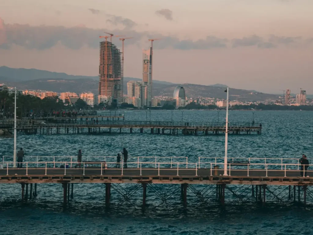 High-rise towers under construction on the Limassol seafront, seen from a pier at dusk, Cyprus