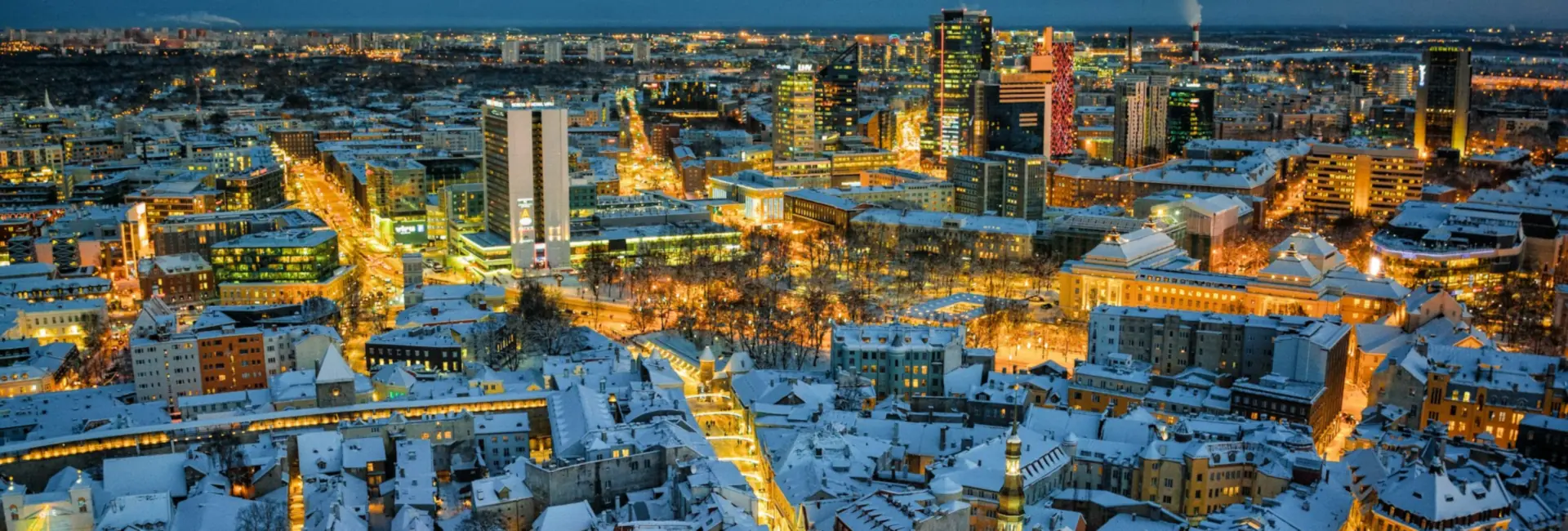 Office towers of the Tallinn city centre above the snow-covered roofs of the Old Town at night, Estonia