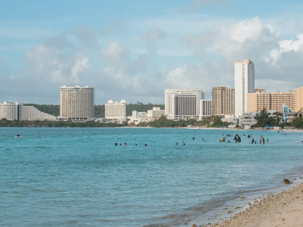 Swimmers in Tumon Bay with the hotel district of Tumon behind, Guam