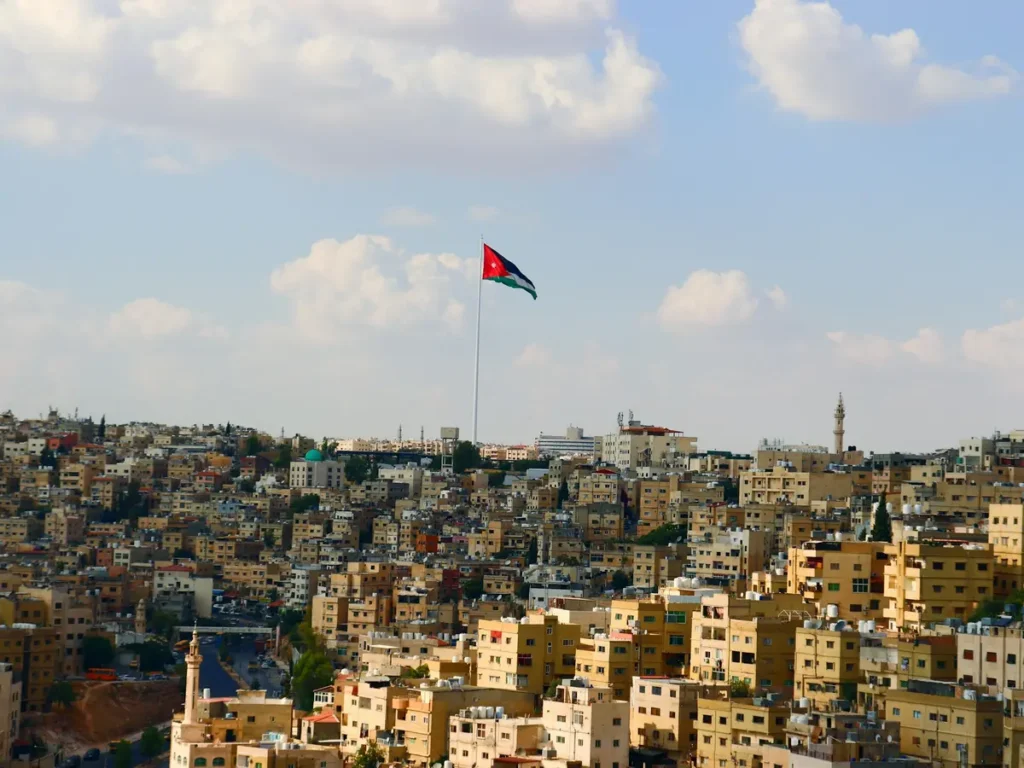 The Jordanian flag flying above the hillside neighbourhoods of Amman, Jordan